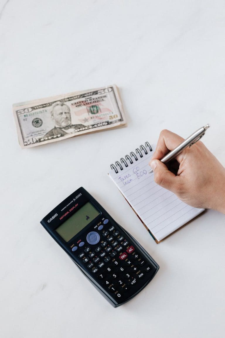 financial worker calculating profit using notebook and calculator